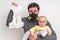 Father with gas mask is holding stinky diaper and little baby