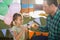 Father and girl toasting their tea cups while playing with toy kitchen set