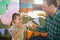 Father and girl toasting their tea cups while playing with toy kitchen set