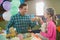 Father and girl toasting their tea cups while playing with toy kitchen set