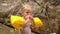 Father Gives Apple to Little Blond Girl in Arm-hands by Rocks