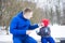 Father gives candy to his daughter.