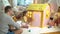 Father gives happy little girl a key to her new cardboard house.