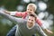 Father Giving Son Piggyback In Countryside