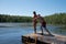 Father going to push his daughter in the lake from pier.