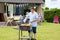 Father grilling meat in the garden for lunch