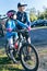 Father guiding his daughter to his mountain bike training in a parking lot