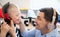 Father with happy down syndrome son indoors at home, using headphones.