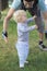 Father hedging their baby, toddler learning to walk