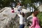 Father Helping Children To Jump Off Rocks