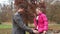 Father helping daughter put on jacket in the park