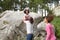 Father Helping Daughter To Jump Off Rocks