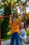 Father helping daughter to pull up on the uneven bars at the playground. Healthy family concept