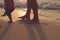 Father helping his baby with the first steps, teaching baby to walk concept, outdoor candid photo on the beach, spending