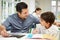 Father Helping Son With Homework Using A Tablet