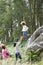 Father Helping Son To Jump Off Rocks