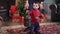 Father helps his little son to hold in his hands of an old antique lamp on the background of the Christmas tree under