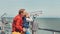 Father helps his little son to look in sea binoculars