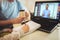 Father helps his son with home work. Boy in video conference with teacher on laptop at home