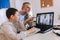 Father helps his son with home work. Boy in video conference with teacher on laptop at home