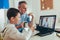 Father helps his son with home work. Boy in video conference with teacher on laptop at home