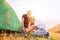 Father helps his son setting tent on sunset forest glade