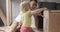 Father and his daughters repair and paint together furniture table. Little girl helps her dad in carpentry workshop.