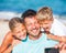 Father and his kids at beach taking selfie