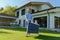 Father with his little daughter carring solar panel at their backyard. Alternative energy, saving resources and