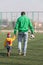 Father with his little son are going to play football, soccer in the park