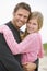 Father holding daughter at beach