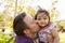 Father holding and kissing his young daughter in a park