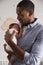 Father Holding Newborn Baby Son In Nursery