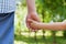 Father holds hand of the little child against beautiful bokeh background in sunny summer day, happy family concept