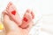 Father holds a small leg of a newborn baby. hearts for parents d