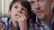 Father hugging son while watching thriller movie together popcorn, discussing