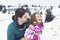 Father hugs his daughter affectionately in the snow