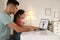 Father installing parental control app on laptop to ensure child`s safety at home