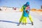 Father or instructor teaching little skier how to make turns