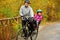 Father and kid on bike, cycling in autumn park