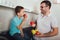 Father and kid standing in kitchen in embrace. They holding fruit in hands