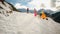 Father and kids, pulling empty wooden sleds uphill