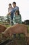 Father With Kids Watching Pigs Feed In Sty