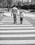 father leading his son through zebra crossing, togetherness