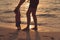 Father and little baby daughter walking on sand beach.