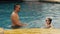 The father with little daughter have fun in the pool. Dad plays with the child. The family enjoy summer vacation in a