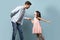 Father and little daughter holding hands dancing waltz studio shot