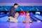 Father with little daughter playing bowling
