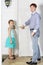 Father and little daughter stands near white entrance door