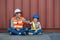 Father and little daughter wearing a safety helmet at Container cargo site. Business heir concept. Happy father and daughter weari